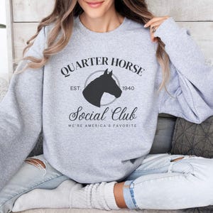 May include: Gray sweatshirt with a black graphic design that says "Quarter Horse Social Club Est. 1940 We're America's Favorite"
