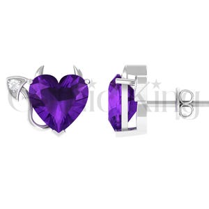 May include: A pair of silver stud earrings. One earring features a heart-shaped, faceted, deep purple amethyst with small horns and a tail. The other earring is a heart-shaped amethyst in a silver setting.
