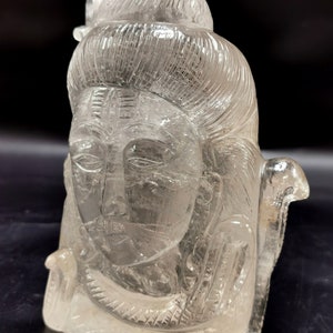 Könnte beinhalten: Eine klare Kristallsculptur der hinduistischen Gottheit Shiva mit einem detaillierten Gesicht und komplizierten Haaren. Die Skulptur ist aus einem einzigen Stück klarem Quarz geschnitzt.
