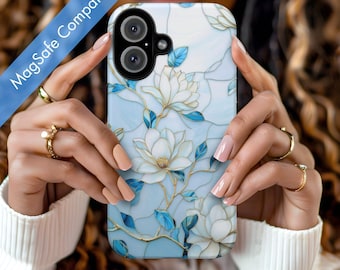 May include: A white phone case with a blue and white floral design. The case has a clear camera lens and a MagSafe compatible design.