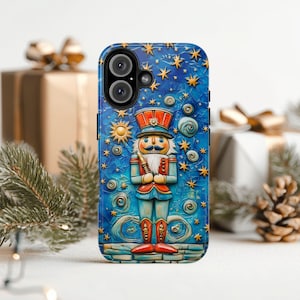 Puede incluir: Una funda de teléfono azul con una ilustración detallada de un cascanueces soldado sobre un fondo de noche estrellada. El cascanueces sostiene un bastón dorado y lleva un sombrero rojo y un uniforme azul.