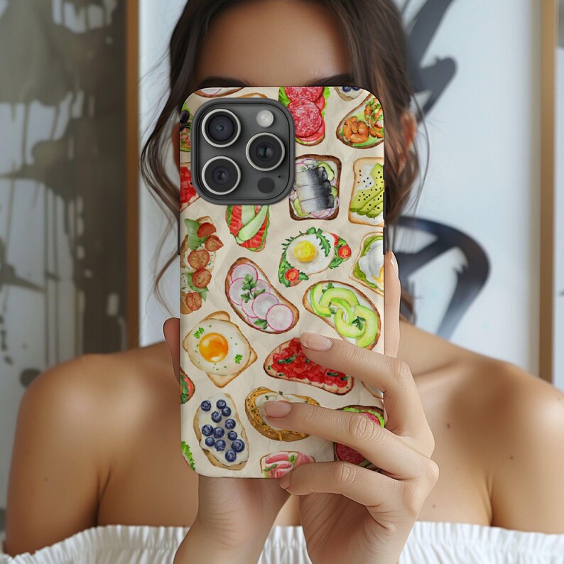 Op de afbeelding: Een telefoonhoesje met een kleurrijk patroon van verschillende soorten toast met verschillende toppings. Het hoesje is gemaakt van hard plastic en heeft een transparante achterkant.