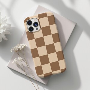 May include: A brown and beige checkered phone case for an iPhone.