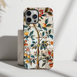 Puede incluir: Una funda blanca para iPhone 12 Pro Max con un diseño floral colorido. El diseño presenta un árbol con hojas verdes, frutos rojos y naranjas y flores blancas sobre un fondo de azulejos.