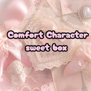 May include: A light pink decorative box featuring the text Comfort Character sweet box, adorned with lace heart trim, satin ribbons, pearl strands, a small cherub figurine, and a heart-shaped embellishment with a white center.