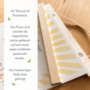 May include: A poster hanging system with wooden magnetic strips. The poster is held between the strips and can be easily changed. The text on the poster says "Auf Wunsch mit Posterleiste" and "Aus hochwertigem Kiefernholz gefertigt".