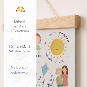 May include: A children's poster with a wooden frame, featuring illustrations of a sun, kite, and children. The poster has German text, including affirmations like "I am wonderful" and "I am good."