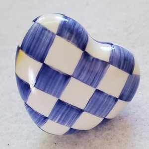 Può includere: Pomello decorativo a forma di cuore con motivo a scacchi blu e bianco. Il pomello è realizzato in ceramica o porcellana e ha una finitura lucida. I quadrati blu hanno un aspetto dipinto a mano.