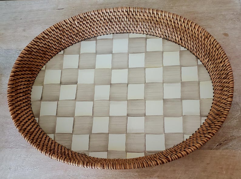 Puede incluir: Bandeja ovalada de rat&aacute;n tejido con un patr&oacute;n interior a cuadros. El borde de la bandeja est&aacute; hecho de rat&aacute;n tejido apretadamente, y el interior presenta una cuadr&iacute;cula de cuadrados claros y blanquecinos alternados. Esta bandeja decorativa es adecuada para servir o exhibir.