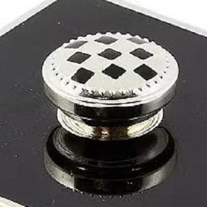 May include: A circular metal knob featuring a silver-toned finish with a repeating black diamond pattern on the top surface. The edge of the knob has a textured, beaded border, and the base is a smooth, reflective silver-toned metal cylinder.