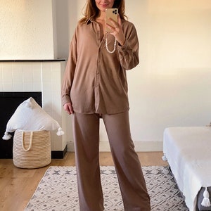 May include: A brown ribbed knit pajama set with a collared button-up top and wide-leg pants.