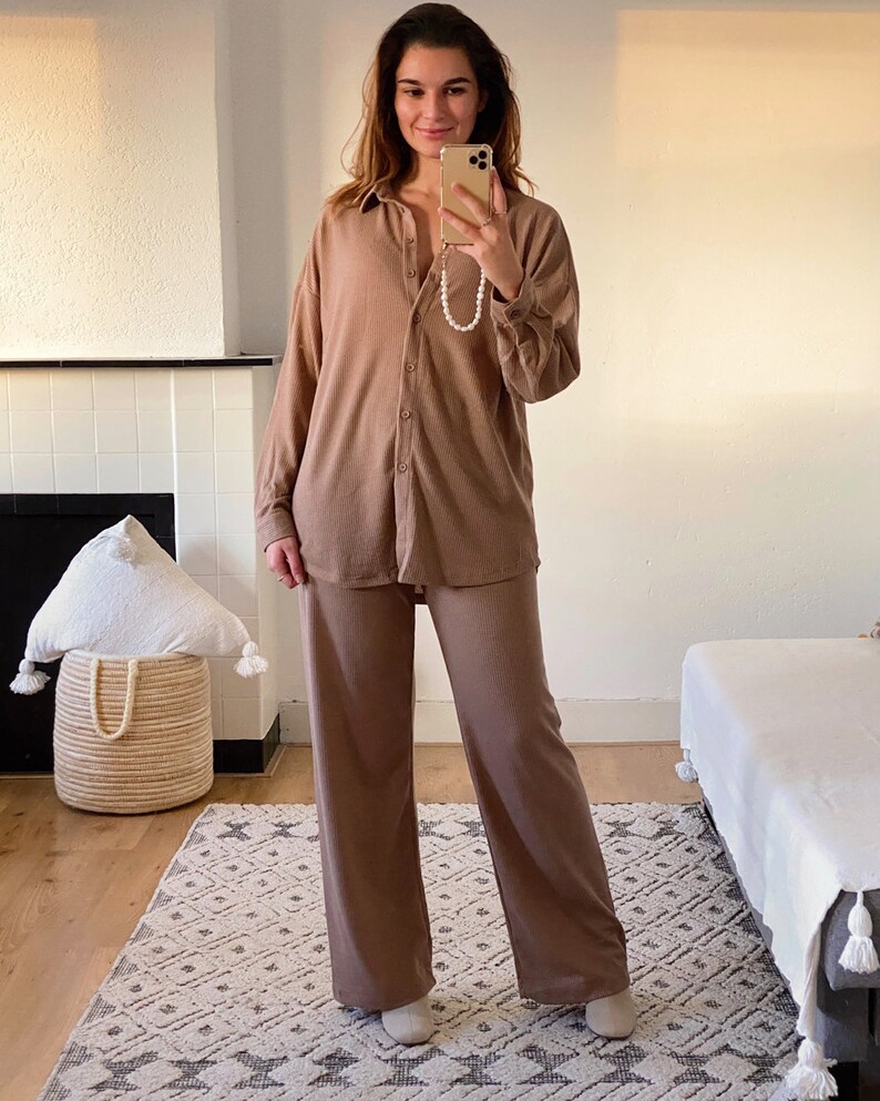 May include: A brown ribbed knit pajama set with a collared button-up top and wide-leg pants.