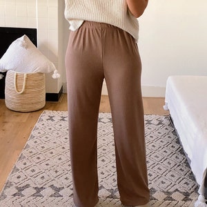 May include: A pair of wide-leg, brown ribbed pants with a high waist and a relaxed fit.