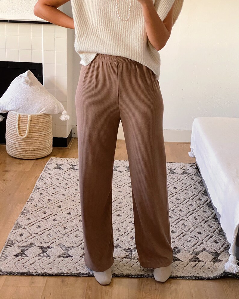 May include: A pair of wide-leg, brown ribbed pants with a high waist and a relaxed fit.