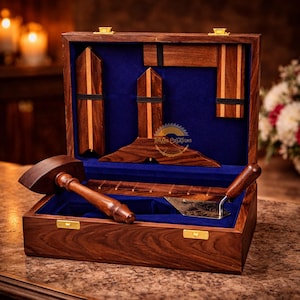May include: A wooden toolbox with a blue velvet interior, containing various woodworking tools. The tools include a mallet, a trowel, and several geometric shapes. The box is made of dark wood with gold-colored hardware.