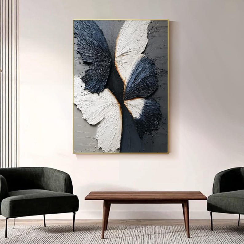 Pu&ograve; includere: Opera d'arte astratta a farfalla in cornice dorata. L'opera presenta ali strutturate nei toni del bianco e blu navy su sfondo grigio. Un elemento di arredo moderno per la casa, adatto a soggiorni o camere da letto.