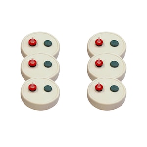 May include: Six white round lids with two small red and green buttons on each lid. The lids are for preserving jars.