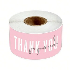 May include: Roll of pink thank you stickers with white text that says "Thank you for your order".