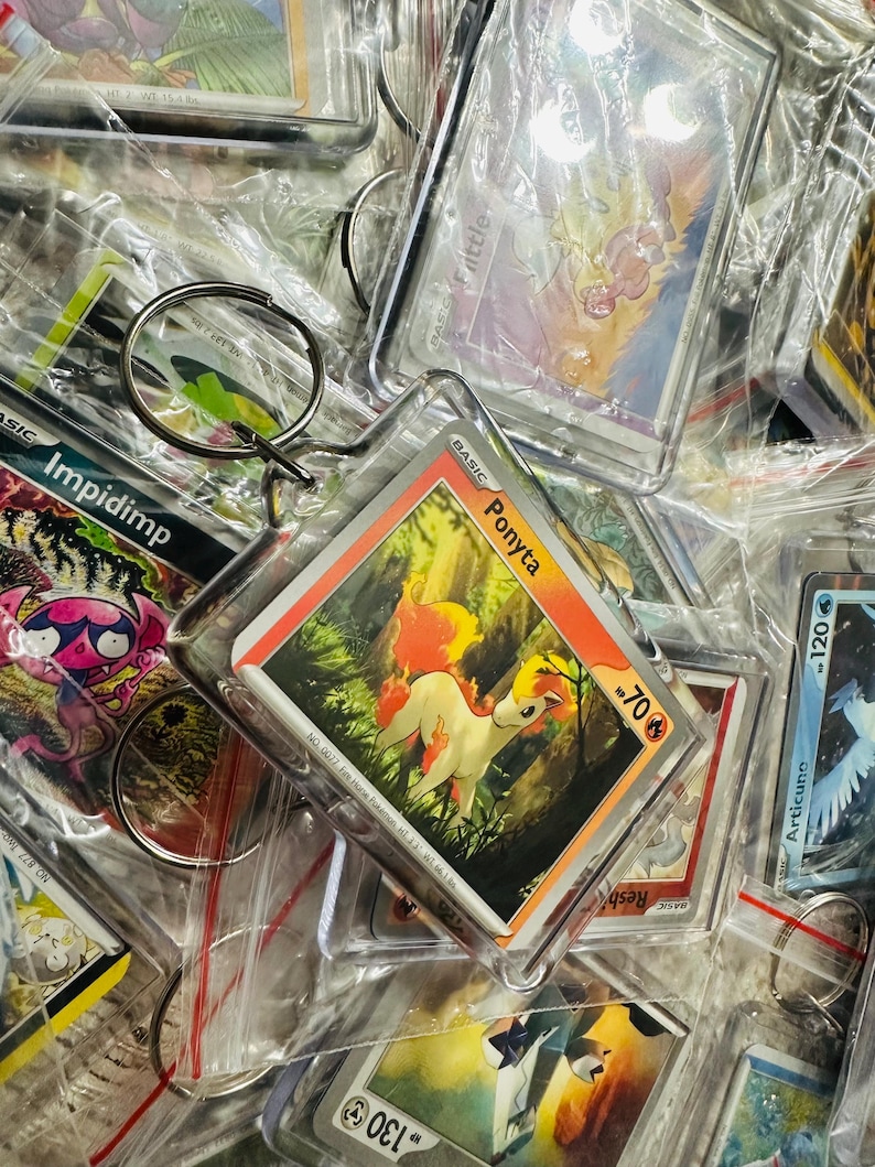 Pu&ograve; includere: Una collezione di carte da scambio Pok&eacute;mon in buste di plastica, con personaggi come Impidimp, Ponyta e Articuno. Le carte sono attaccate a portachiavi, il che le rende perfette per collezionisti o fan.