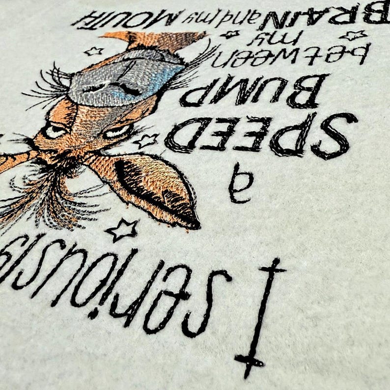 May include: Embroidered design on a white fabric featuring a cartoon animal with a long nose and large ears. The text reads "I seriously  a SPEED BUMP  between my BRAIN and my MOUTH".