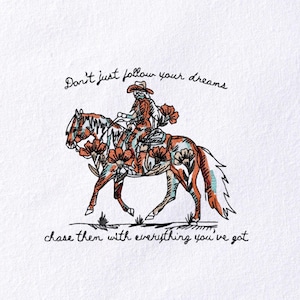 May include: An embroidered design on white fabric shows a person riding a horse decorated with floral patterns. The text reads, "Don't just follow your dreams, chase them with everything you've got."