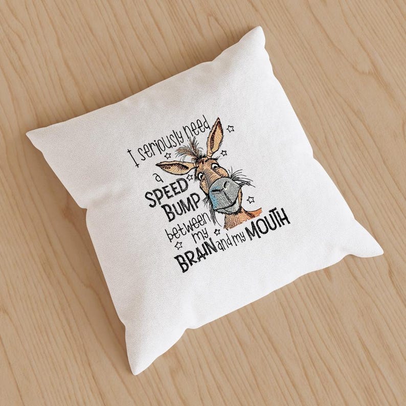 May include: White throw pillow with a cartoon donkey and the text "I seriously need a speed bump between my brain and my mouth".