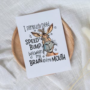May include: A white card with a cartoon donkey and the text "I seriously need a speed bump between my brain and my mouth".