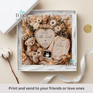 May include: A white gift box containing a wicker basket filled with dried flowers, a light brown teddy bear, a pair of beige knit booties, a heart-shaped sign reading "We've been keeping a little secret, arriving November 202X", and a baby onesie.
