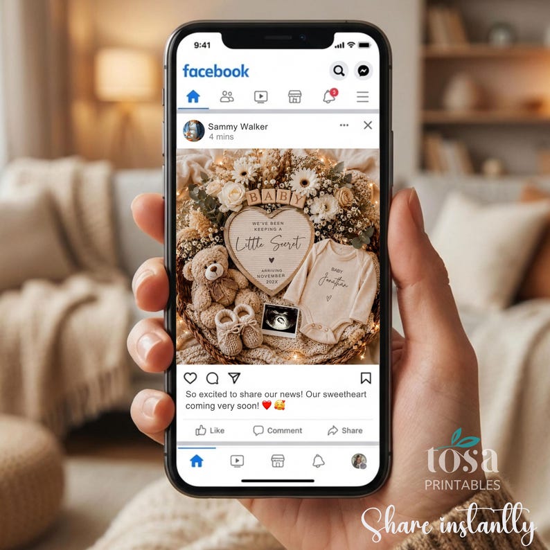 May include: A smartphone screen displaying a Facebook post featuring a baby announcement with a heart-shaped letter board reading 'We've been keeping a little secret', a teddy bear, baby booties, a onesie, and an ultrasound image in a wreath.