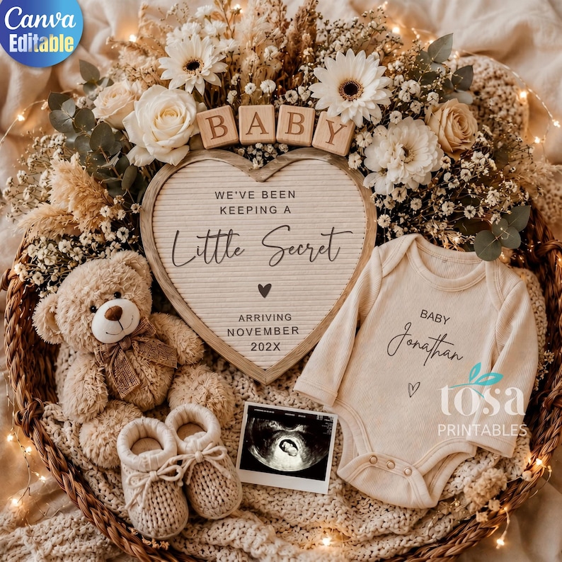 May include: A wicker basket containing a heart-shaped letter board with the text 'WE'VE BEEN KEEPING A LITTLE SECRET ARRIVING NOVEMBER 202X', a beige baby bodysuit with 'BABY Jonathan', a teddy bear, knitted booties, and an ultrasound photo.