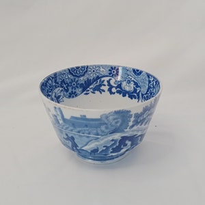 Könnte beinhalten: Eine weiße Keramikschüssel mit einem blauen und weißen Blumenmuster. Die Schüssel zeigt eine Szene mit einem Haus und Bäumen auf dem Land.