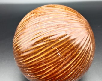 Brown odd ball size of a cricket ball rigged over surface, ceramic