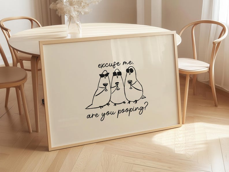 May include: A framed art print featuring three cartoon birds in sunglasses, each holding a wine glass. The black text reads "excuse me, are you pooping?" The artwork is displayed on a light-colored background.
