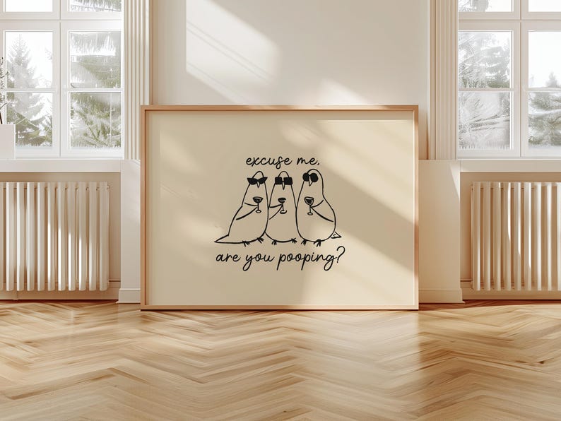 May include: A framed print featuring three cartoon birds wearing sunglasses and holding wine glasses. The text on the print reads "excuse me, are you pooping?" The artwork is displayed on a light-colored background.