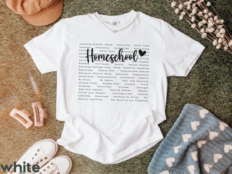 May include: White t-shirt with a black graphic that says "Homeschool" and lists a variety of homeschooling benefits, including "Learning Without Limits", "Family Time", "Real-Life Lessons", "Natural Learning", and "The World is Our Classroom".