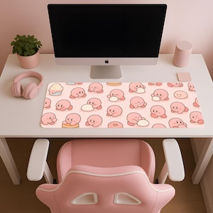 Peut inclure: Un bureau rose avec un ordinateur, un casque et un tapis de souris. Le tapis de souris présente un motif répété d'un personnage de dessin animé rose avec des aliments. Une chaise rose est devant le bureau.