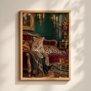 May include: A framed wall art print depicting a leopard resting on a deep red velvet tufted sofa. The scene includes dark green panelled walls, gold wall sconces with lit candles, a floral arrangement, and a marble-topped table with glassware.