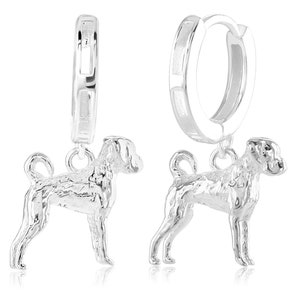 Pode incluir: Brincos de argola de prata com um pingente de um cão boxer. Os brincos são de prata e o pingente de cão é detalhado.