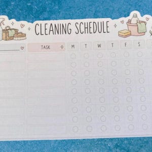 May include: A rectangular cleaning schedule planner sheet with a white background and pastel illustrations of cleaning supplies. The header reads CLEANING SCHEDULE, followed by columns for tasks and days of the week with empty circular checkboxes.