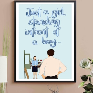 Pode incluir: Impressão de arte emoldurada com fundo azul claro e o texto "Just a girl, standing infront of a boy...". A ilustração mostra uma menina e um menino em um quarto. A moldura é preta.