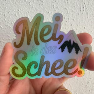 Sticker „Mei, is des Schee!“ – Holografischer Alpen Aufkleber Bayerischer Spruch Heimatliebe Deko Geschenk Bayern Laptop Berge Gipfel