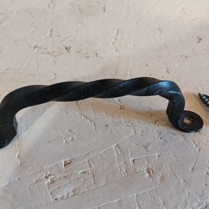 Puede incluir: Pomo de puerta de metal negro retorcido con dos tornillos negros.