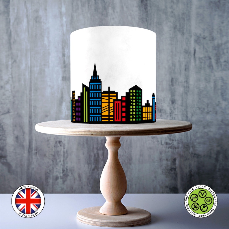 Sheet showing a black city skyline design with colourful red, blue, green, purple, and yellow windows, displayed on a 1cm grid with Made in the UK and vegan, gluten-free, nut-free, dairy-free, GMO-free certification icons.