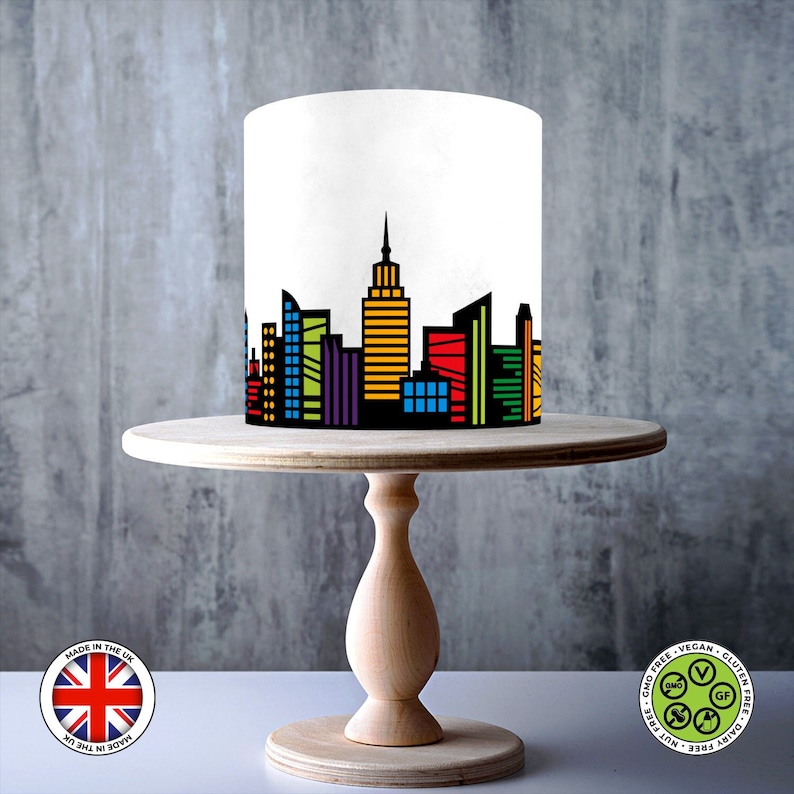 Sheet showing a black city skyline design with colourful red, blue, green, purple, and yellow windows, displayed on a 1cm grid with Made in the UK and vegan, gluten-free, nut-free, dairy-free, GMO-free certification icons.