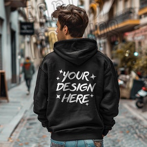 May include: A black hooded sweatshirt with the text "YOUR DESIGN HERE" printed on the back in white.