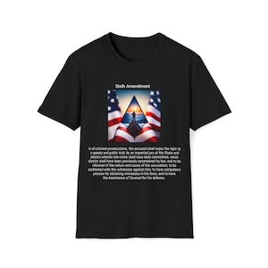 Könnte beinhalten: Ein schwarzes T-Shirt mit einem Grafik des amerikanischen Flagge und dem Text "Sechster Zusatzartikel". Der Text unter dem Grafik lautet: "In allen Strafverfolgungen hat der Angeklagte das Recht auf einen schnellen und öffentlichen Prozess vor einer unparteiischen Jury des Staates und des Bezirks, in dem das Verbrechen begangen wurde, wobei dieser Bezirk zuvor gesetzlich festgestellt wurde, und darauf, über die Art und Ursache der Anklage informiert zu werden; mit den Zeugen gegen ihn konfrontiert zu werden; einen obligatorischen Prozess zur Einholung von Zeugen zu seinen Gunsten zu haben und die Hilfe eines Rechtsbeistands für seine Verteidigung zu haben."