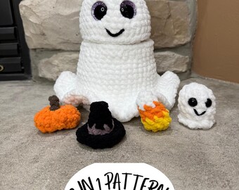Puede incluir: Un conjunto de decoraciones de Halloween hechas a mano con ganchillo. El conjunto incluye un fantasma blanco grande con ojos de purpurina morada, un fantasma pequeño, una calabaza, un sombrero de bruja y caramelos. El texto "2 IN 1 PATTERN Crochet Pattern PDF Download" también es visible.