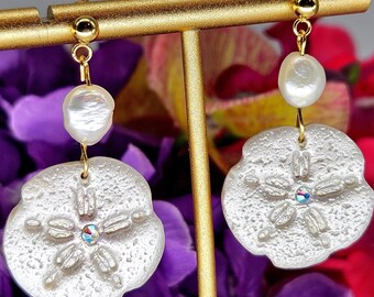 Pendientes colgantes nacarados con forma de dólar de arena: arcilla polimérica y perlas de agua dulce.