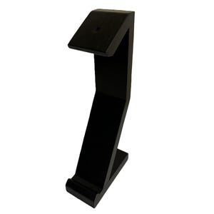 May include: Black wooden stand with a curved design, perfect for displaying a phone or other small device.