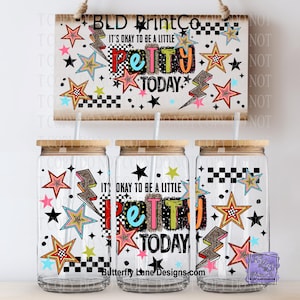 May include: Three glass tumblers with wooden lids and straws, decorated with stars, lightning bolts, and the phrase "It's Okay to be a Little Petty Today." A wooden sign above repeats the design. The tumblers have a clear glass body.